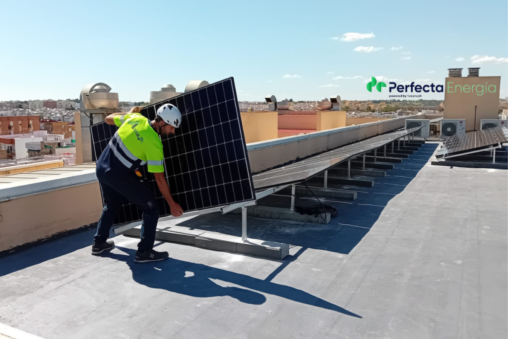 técnico colocando placas solares en comunidades de vecinos