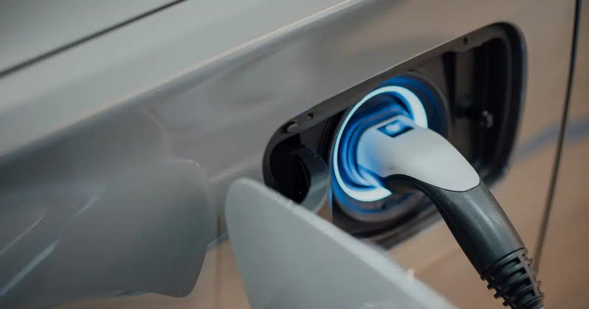 Detalle de un punto de recarga: cargador eléctrico conectado al puerto de un coche
